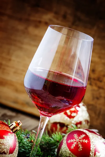 Red wine in the glass, tree branches and Christmas balls — Stock Photo, Image