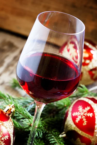 Red wine in the glass, tree branches and Christmas balls — Stock Photo, Image