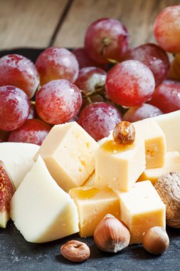 peynir, incir, fındık ve eski ahşap arka plan üzerinde üzüm