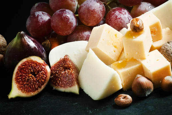 Formaggio, fichi, noci e uva sul vecchio fondo di legno — Foto Stock