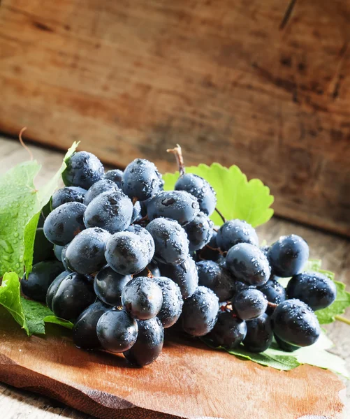 Синій виноград на старому дерев'яному фоні — стокове фото