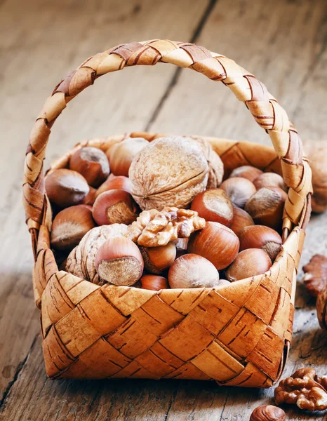 Nocciole e noci in un cestino di vimini — Foto Stock