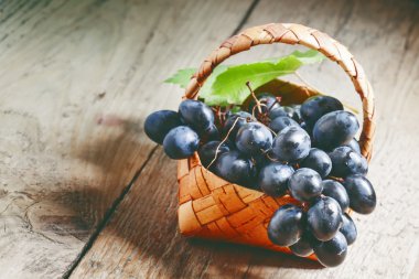 Huş hasır sepet eski ahşap masa içinde Kara üzüm