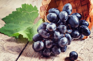 Huş hasır sepet eski ahşap masa içinde Kara üzüm