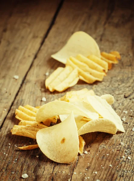 Patatas fritas y sal en mesa de madera vieja — Foto de Stock