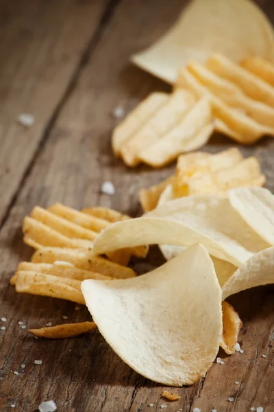 Chips und Salz auf altem Holztisch — Stockfoto