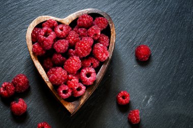 Bir kalp şeklinde bir kase taze frambuaz 