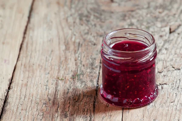 Raspberry jam on the old wooden background — Stock Photo, Image