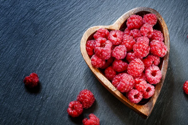 Frische Himbeeren in einer Schüssel in Herzform — Stockfoto