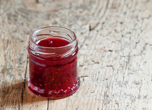 Raspberry jam on the old wooden background — Stock Photo, Image