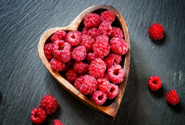 Frische Himbeeren in einer Schüssel in Herzform — Stockfoto