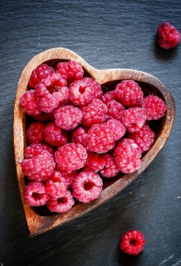 Bir kalp şeklinde bir kase taze frambuaz 