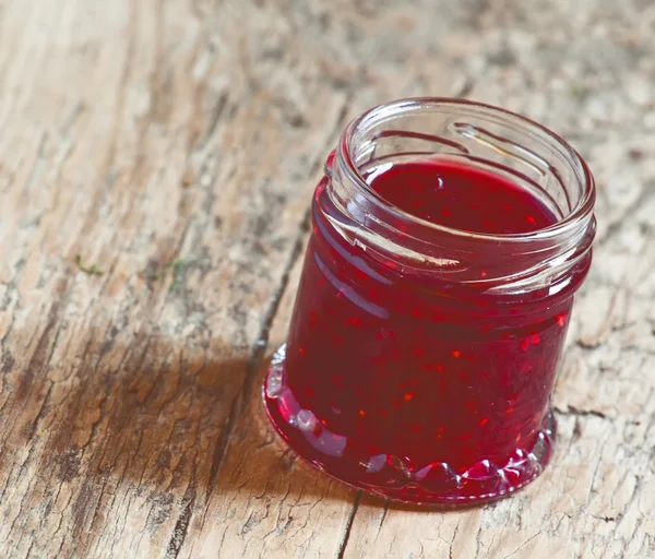 Raspberry jam on the old wooden background — Stock Photo, Image