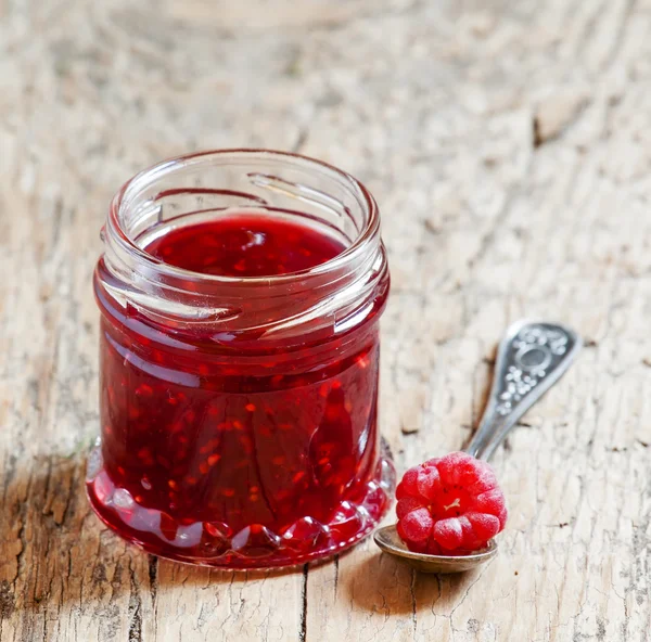 Confiture de framboises dans un bocal et framboise dans une cuillère — Photo