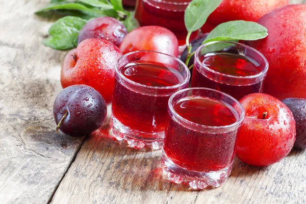 Вкусный свежий сок из красных и синих сладких слив — стоковое фото
