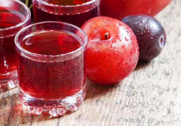 Köstlicher frischer Saft aus roten und blauen süßen Pflaumen — Stockfoto