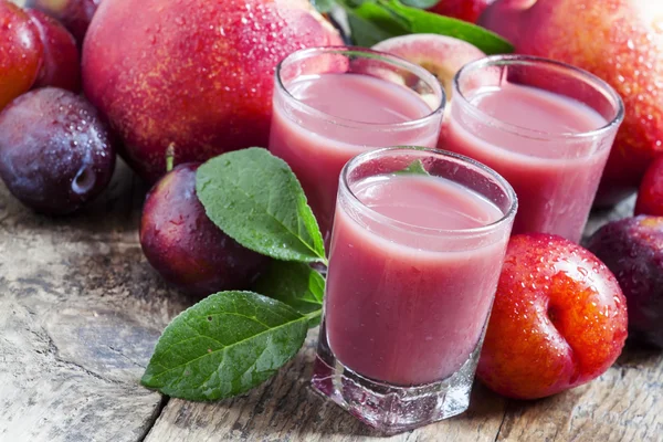 Ízletes friss gyümölcslé, vörös és kék édes szilva — Stock Fotó