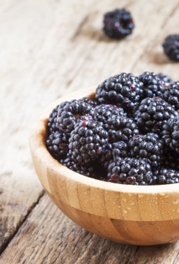 Bir ahşap kase taze böğürtlen