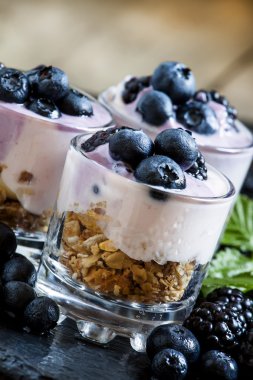 Yoğurt, yaban mersini ve böğürtlen ile ev yapımı granola