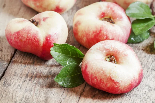 Platte Nectarines met bladeren — Stockfoto