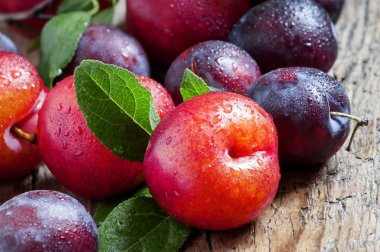 Eski ahşap arka plan üzerinde olgunlaşmış mavi ve kırmızı Erik