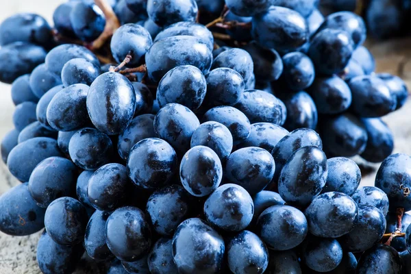 Uvas azules sobre fondo de madera vieja — Foto de Stock