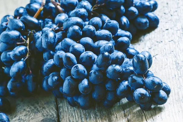 Uvas azules sobre fondo de madera vieja — Foto de Stock