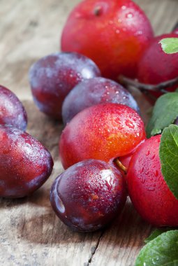 Eski ahşap arka plan üzerinde olgunlaşmış mavi ve kırmızı Erik