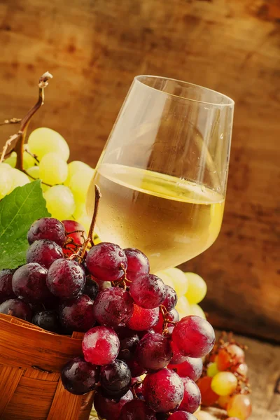 Vinho branco em um copo e uvas verdes e vermelhas — Fotografia de Stock