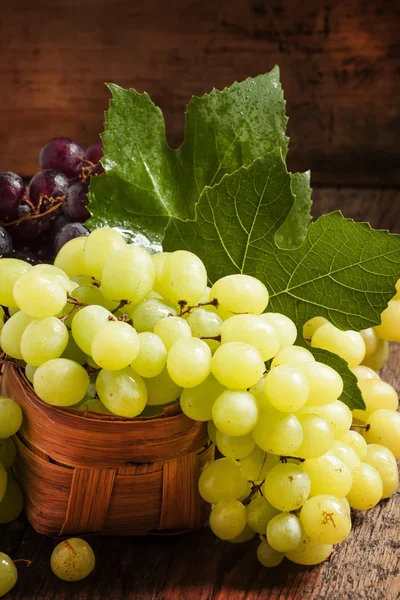 Groene druiven in een rieten mand — Stockfoto