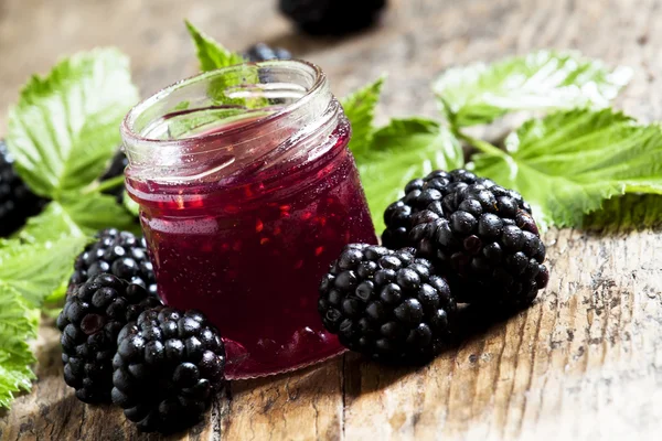 Jar of blackberry jam, fresh berries and green leaves — Stock Photo, Image