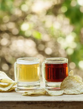 Işık ve karanlık bira bardağı ve patates cipsi