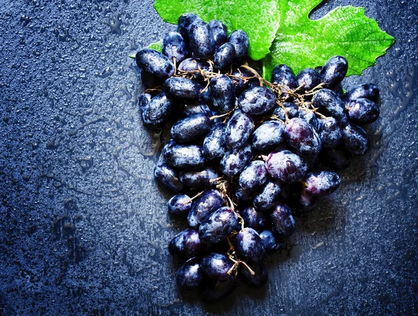 Синий виноград с листьями — стоковое фото