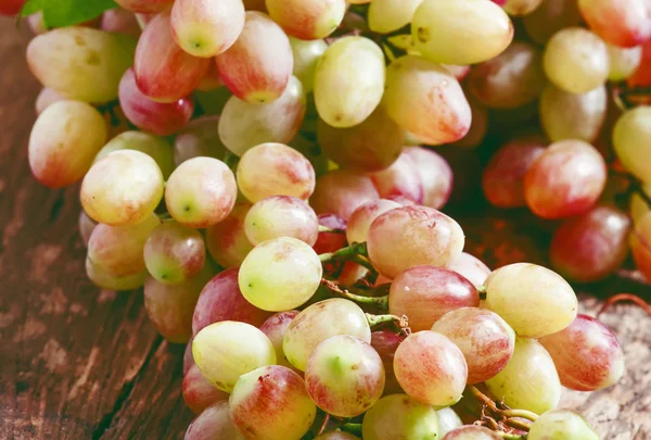 Roze druiven op oude houten tafel — Stockfoto