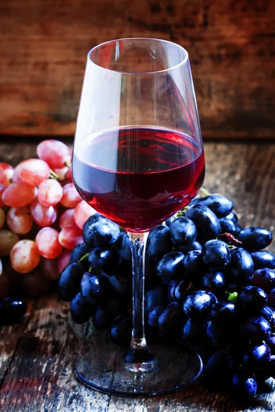Красное вино и голубой и розовый виноград — стоковое фото