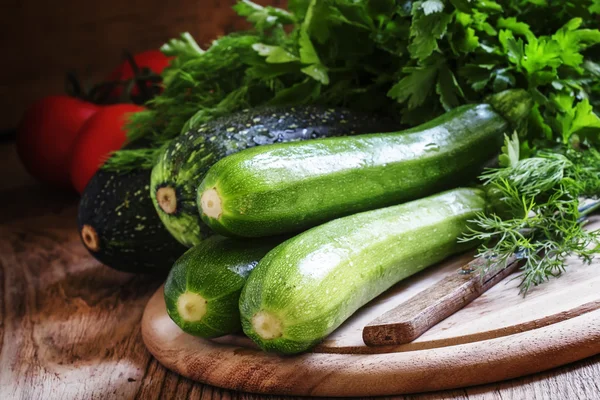 Groene courgette op de houten snijplank — Stockfoto