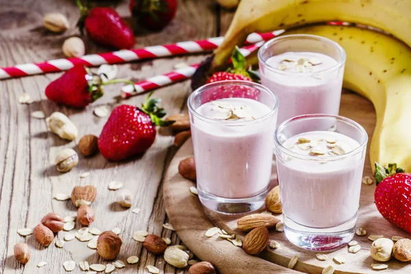 Susu kocok dengan pisang, stroberi, oatmeal dan kacang tanah — Stok Foto