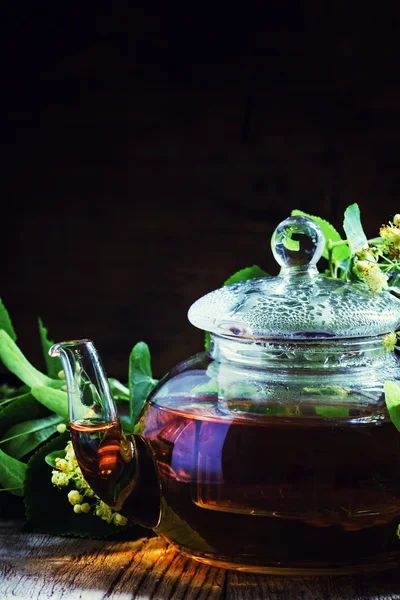 Useful linden tea in glass teapot — Stock Photo, Image