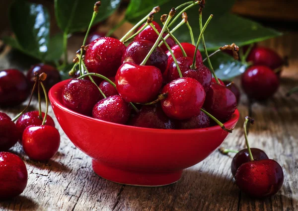 Червоні солодкі вишні в червоній мисці — стокове фото