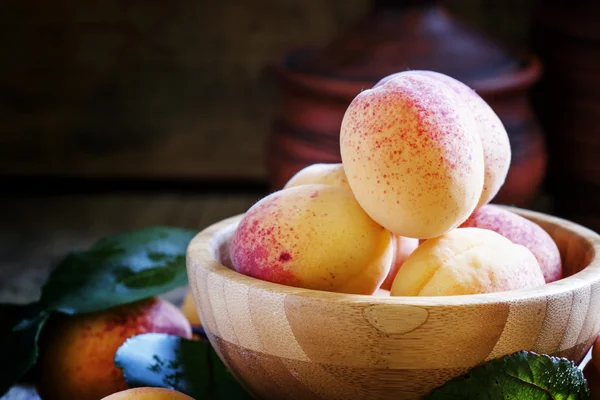 Albaricoques frescos con hojas en un tazón — Foto de Stock