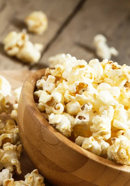 Sweet caramel popcorn in a wooden bowl