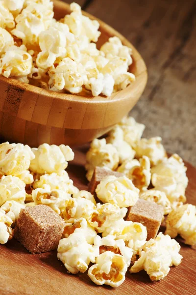 Karamell-Popcorn aus einer Holzschüssel gegossen — Stockfoto