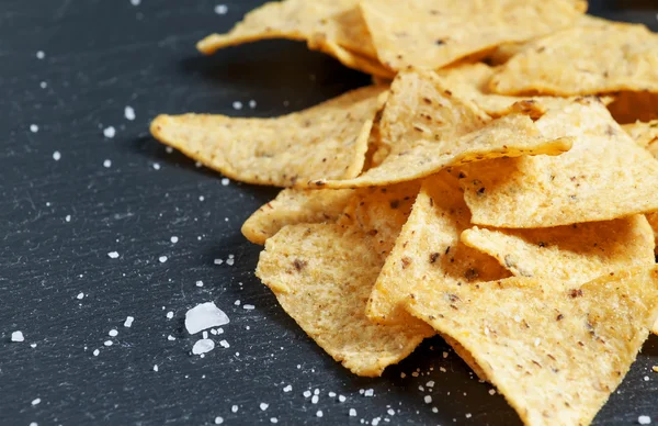 Nachos e sal em um fundo escuro — Fotografia de Stock