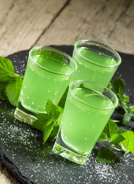 Green cocktail with rum, mint, soda and sugar