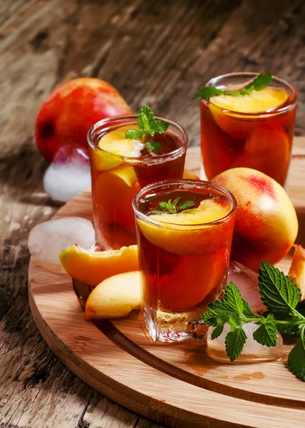 Thé aux pêches glacées avec des morceaux de fruits — Photo