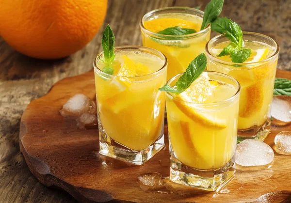 Oranje drinken met soda, mint en fruit — Stockfoto