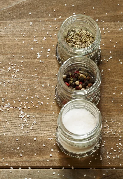 Специи: соль, перец и травы в маленьких стеклянных банках — стоковое фото