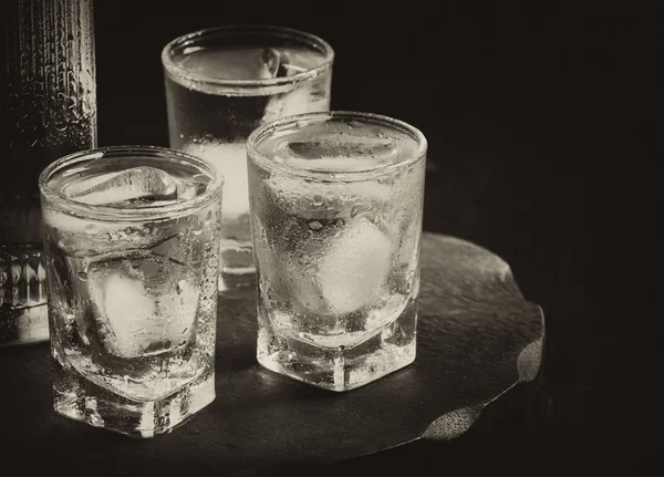 Bottle of vodka and glasses full of ice — Stock Photo, Image