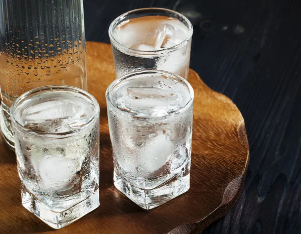 Fles wodka en de glazen vol met ijs — Stockfoto