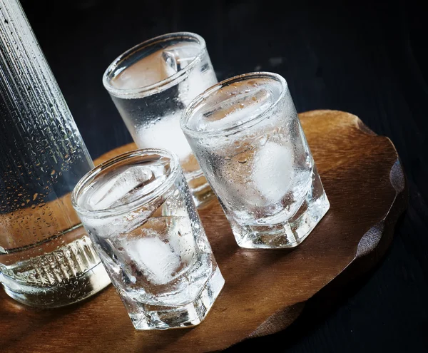Lahev vodky a sklenice plné ledu — Stock fotografie